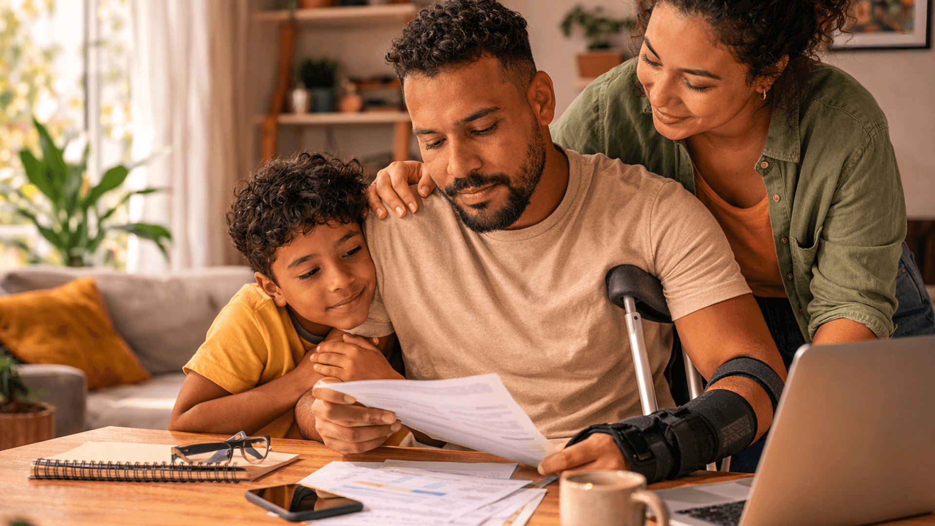 Família acompanhando análise de documentos enquanto um dos membros utiliza suporte ortopédico no braço, representando cobertura para invalidez total ou parcial permanente.